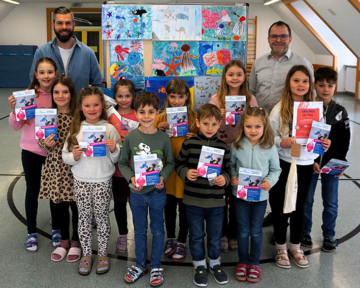 Gruppe von Kindern mit ihrem Lehrer und Herrn Eisenschmid von der Raiffeisenbank
