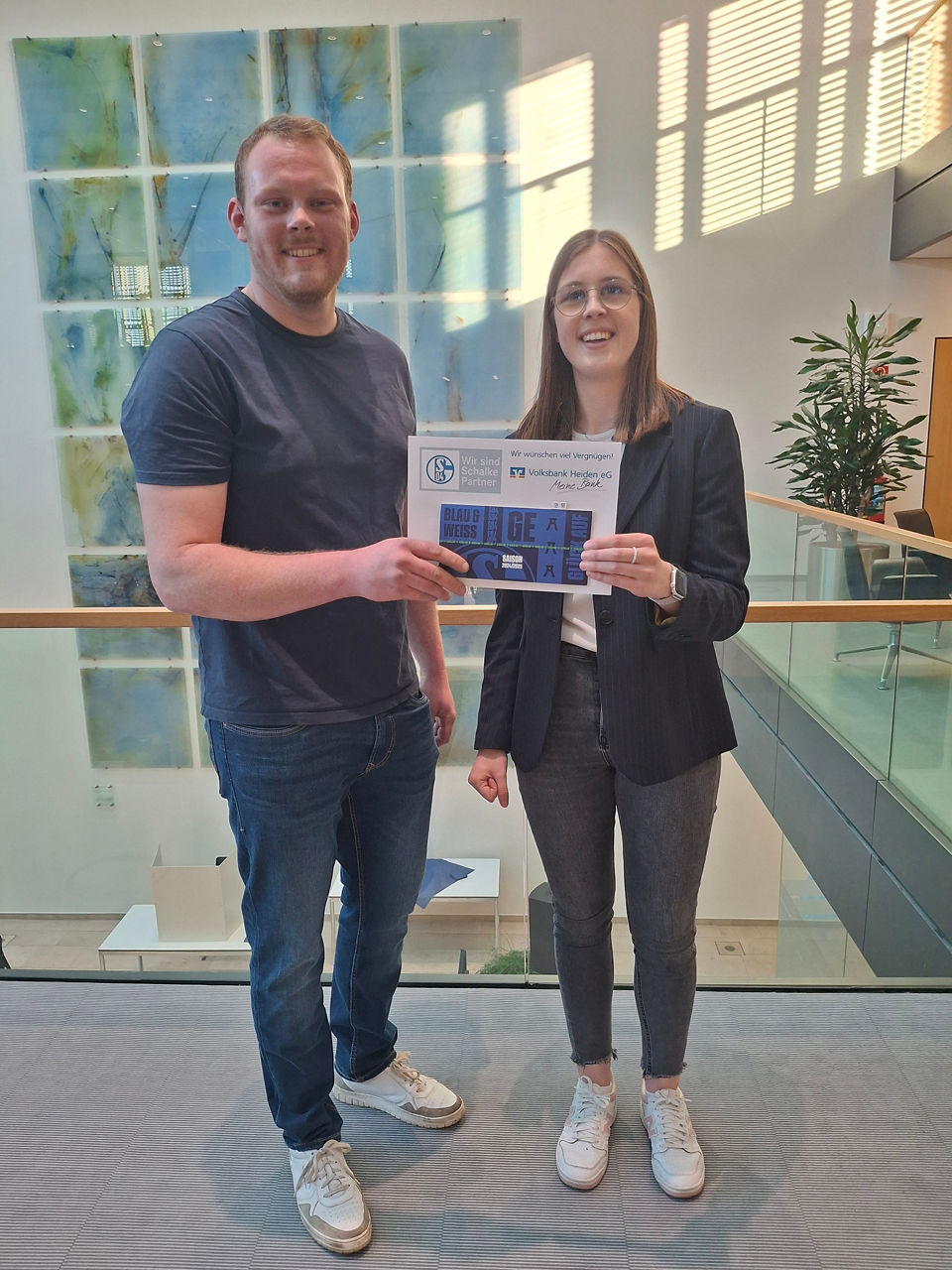 Eine Frau und ein Mann, die ein Schild mit den Namen „BLAU & EGER WEISS“ halten. 