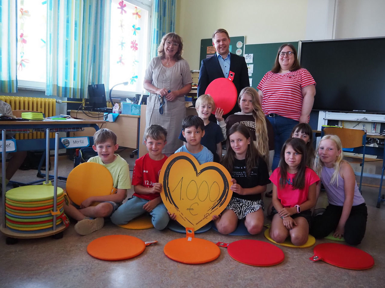 Schulkinder bekommen Sitzkissen von der Bank gespendet