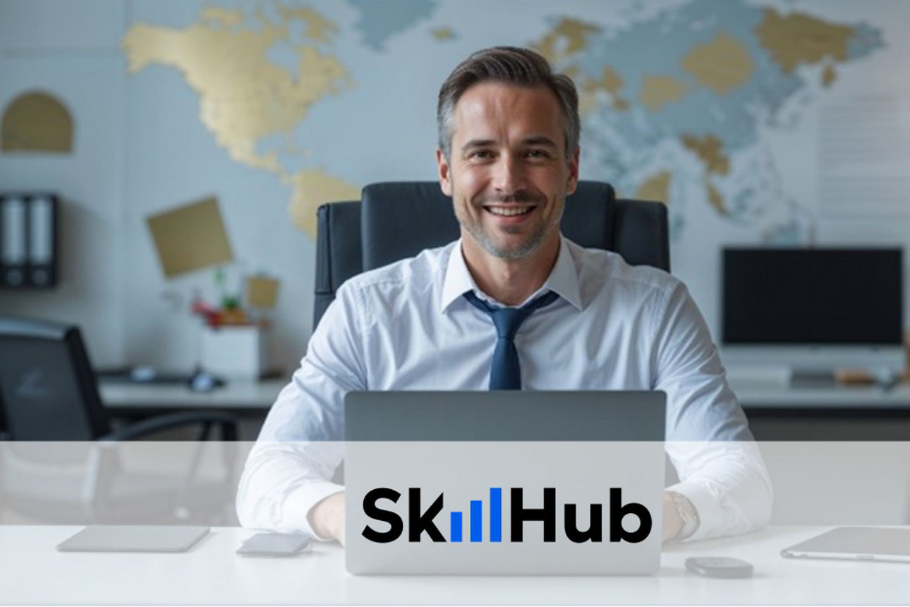 Mann sitzt mit Laptop am Rechner in einem Büro, an der Wand ist eine goldende Weltkarte