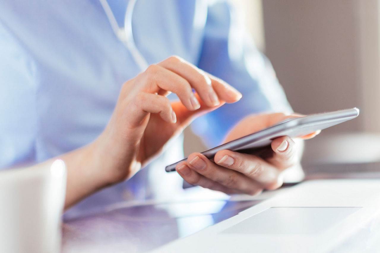 Eine Frau gibt eine Nachricht in ein Smartphone ein