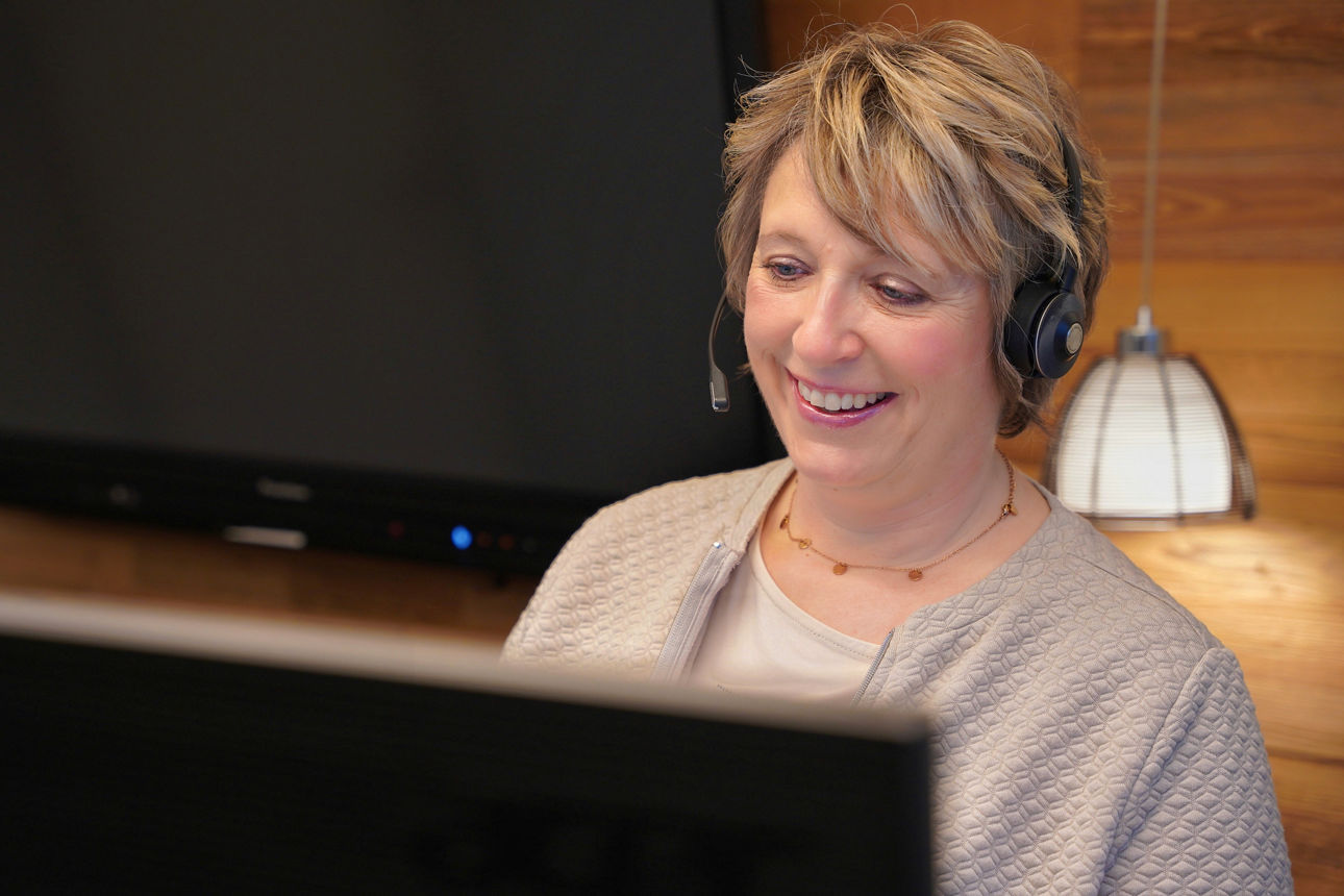 Kundendialogcenter-Mitarbeiterin telefoniert mit ihren Kopfhörern