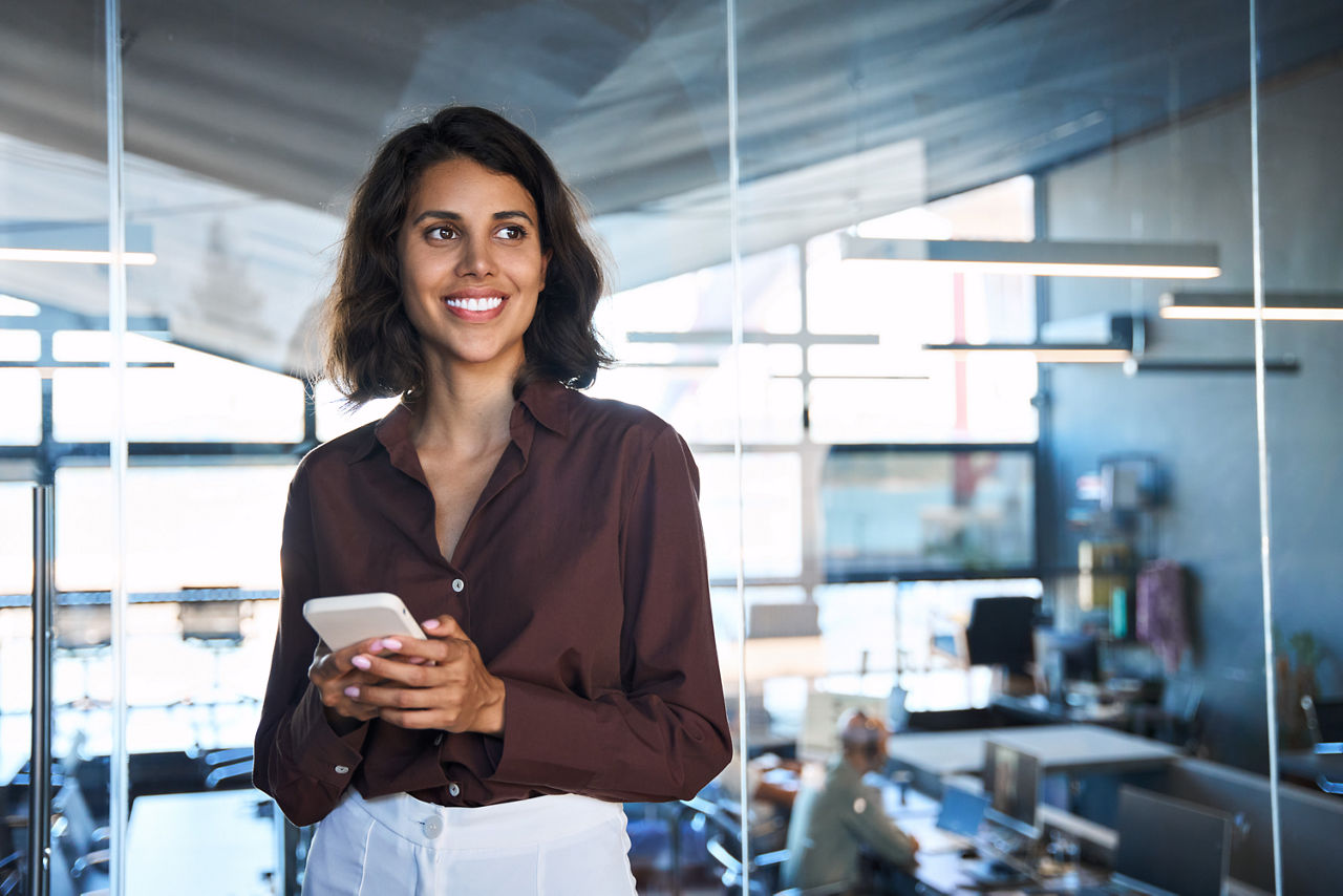 Businessfrau mit Smartphone in moderner Büroatmosphäre