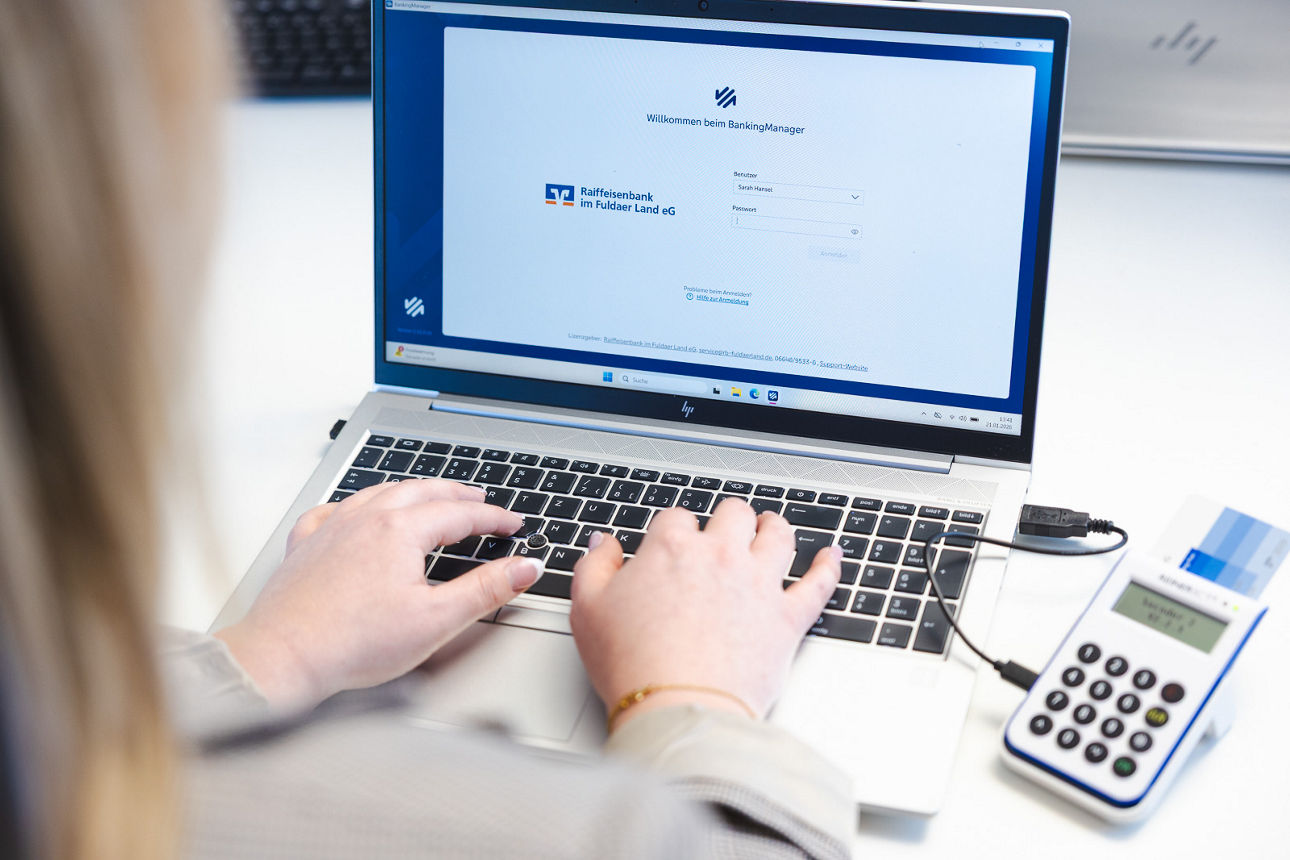 Eine Frau sitzt vor einem Laptop mit Blick auf den Monitor
