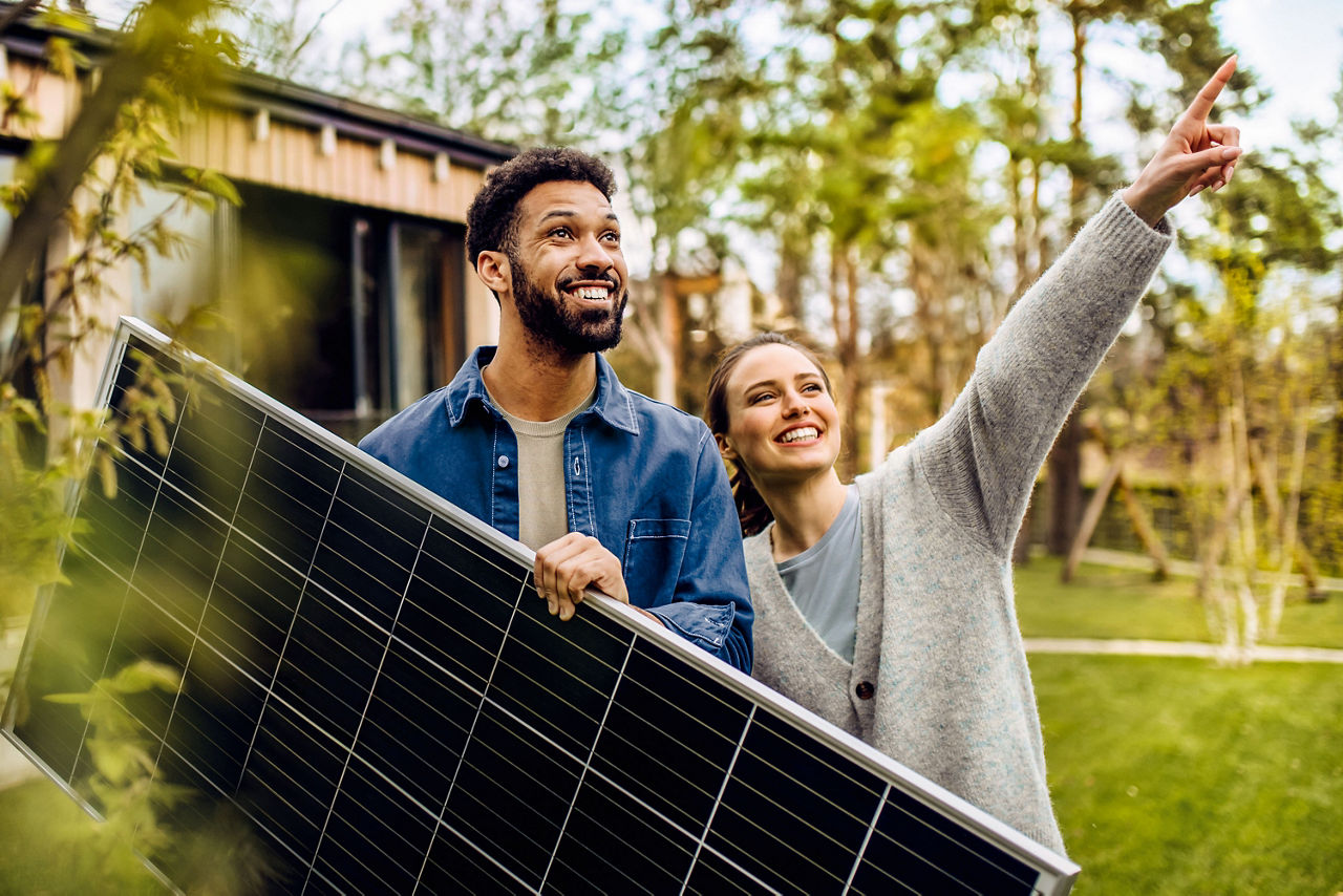 Junges Paar in Garten mit Solarpanel