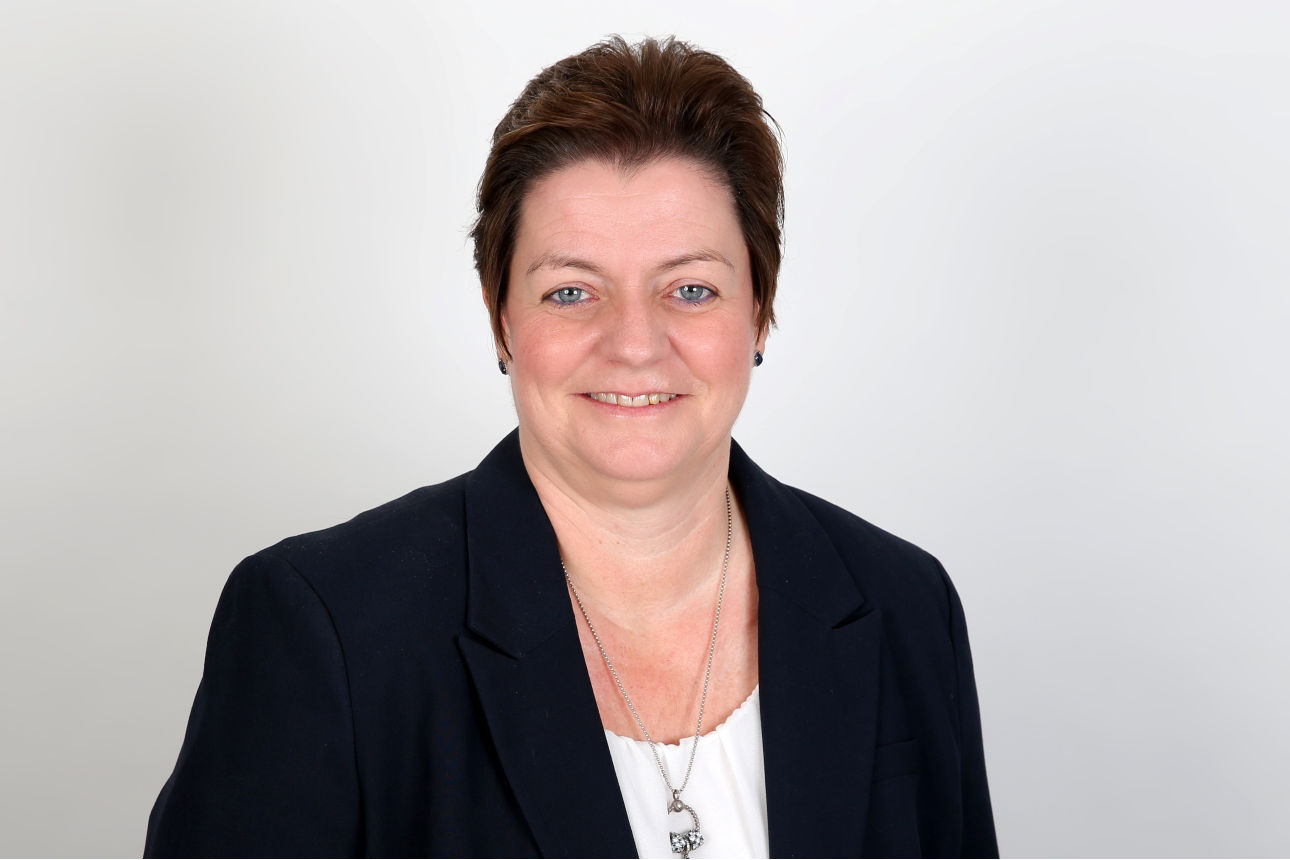 Eine lächelnde Frau schaut in die Kamera.