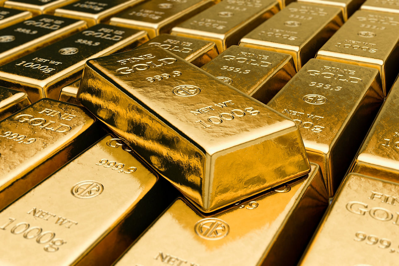 Mehrere Goldbarren liegen gestapelt und dicht nebeneinander; glänzende Metalloberflächen mit Prägung.