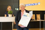 Auf dem Bild sieht man Petra Wollschläger des Freundeskreis Gladbeck-Alanya aus Gladbeck, die den Sonderpreis in der Kategorie Vereine angenommen hat. Im Hintergrund erkennt man hinter dem Pult das Jurymitglied Kirsten Sassning.