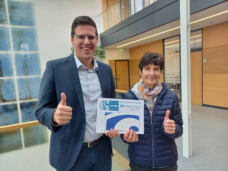 Ein Mann und eine Frau halten die Tickets zusammen und lächeln in die Linse der Kamera