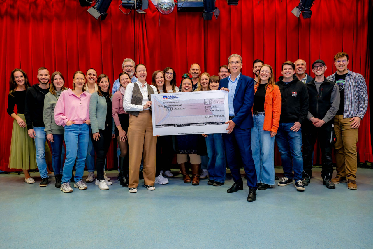 Die Sound of Musicals Gruppe bekommt einen Scheck von dem Volksbank Vorstand überreicht