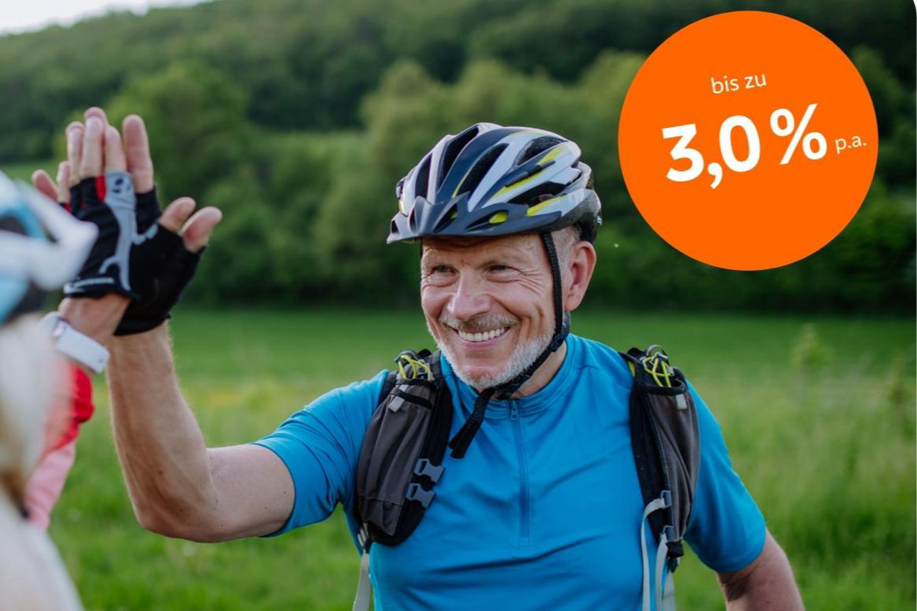 Älterer Herr mit Fahrrad und Fahrradhelm gibt High-Five