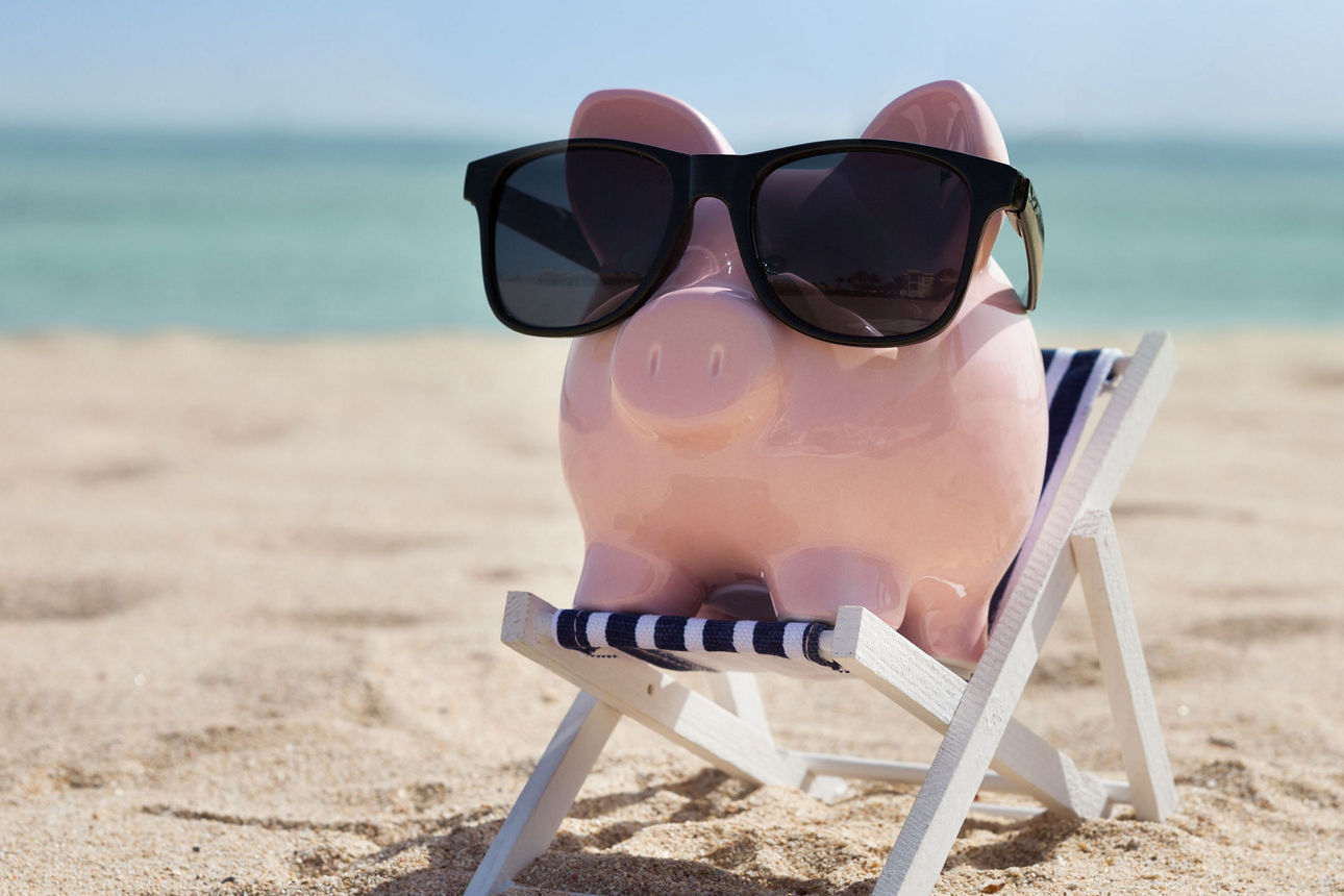 Sparschwein auf Liegestuhl am Strand mit Sonnenbrille 