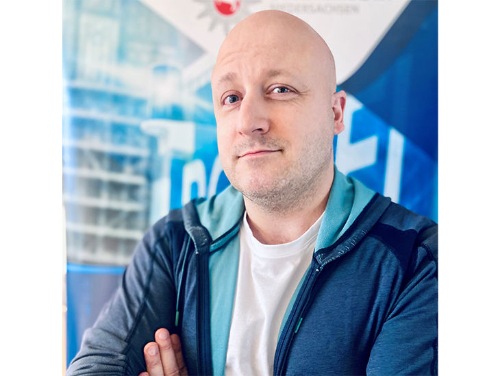 Herr Henschel mit blauem Hintergrund