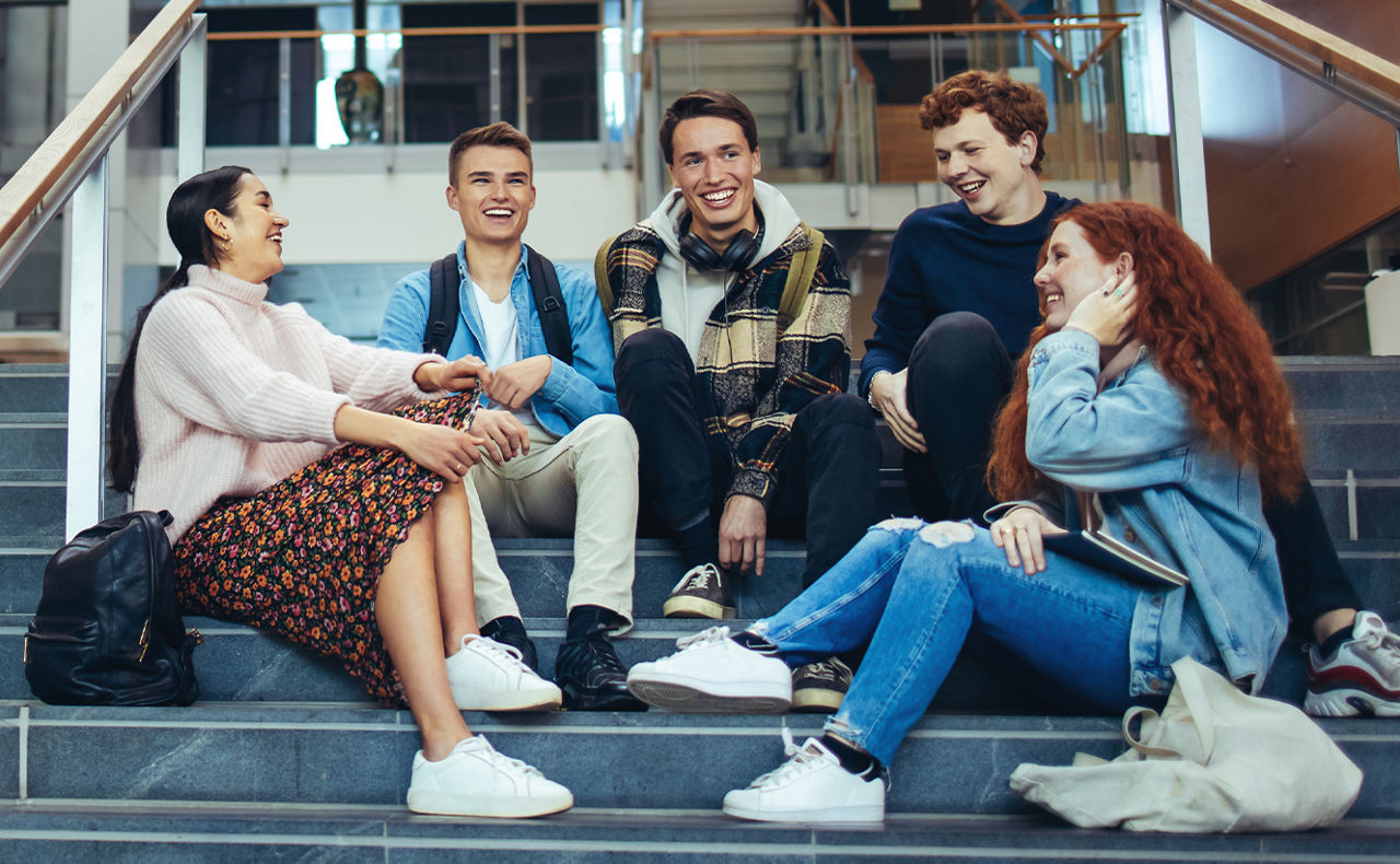 Gruppe Menschen sitzt zusammen auf einer Treppe