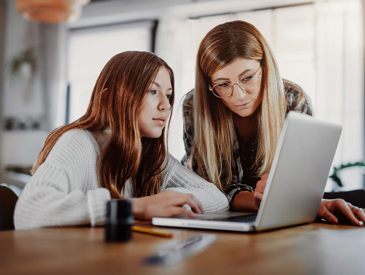 Zwei Frauen schauen gemeinsam auf einen Laptop