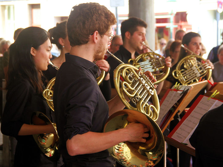 Mehrere Personen machen Musik mit ihren Blasinstrumenten
