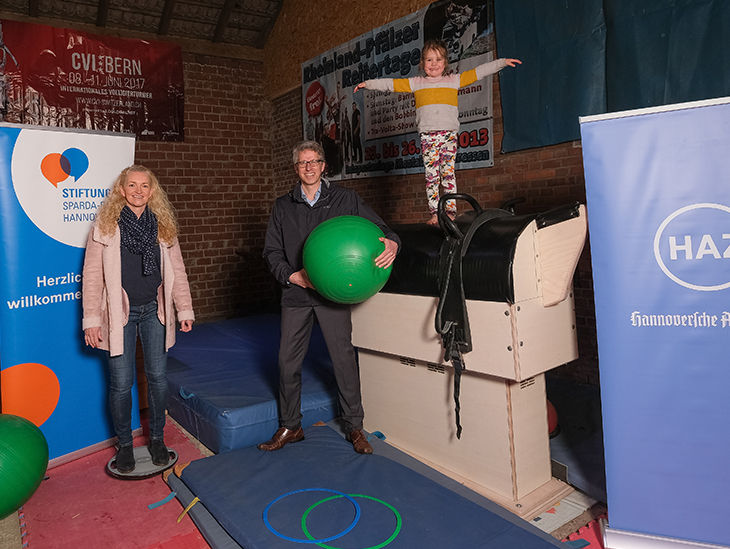Frau, Mann und Kind mit Turnequipment