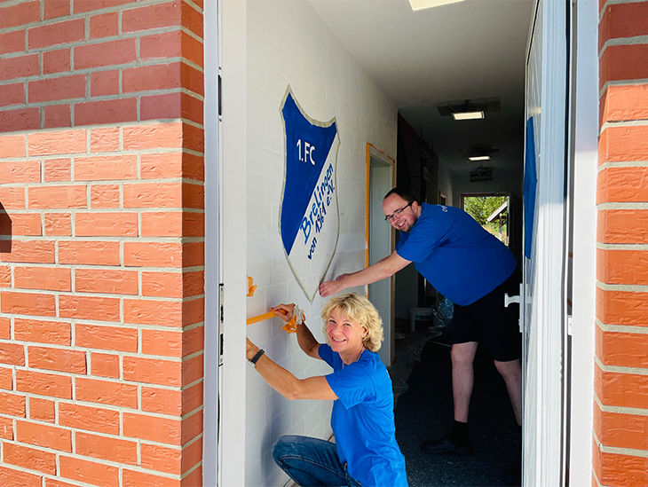 Mann und Frau präperieren eine Wand zum Streichen