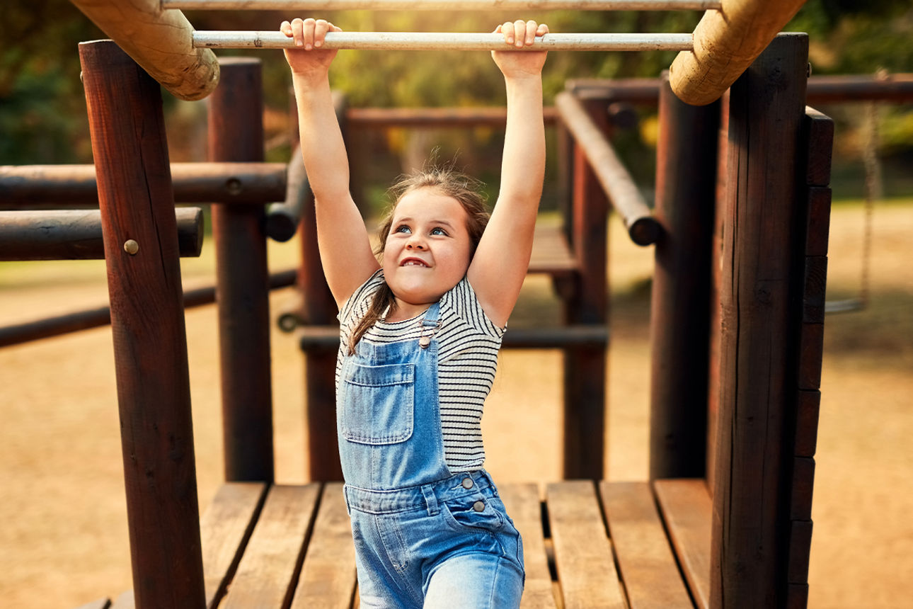 Kind hängt an einem Gerüst