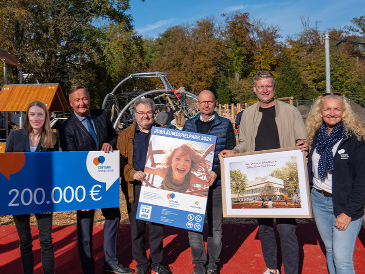 Mehrere Personen halten Schilder hoch bei der Spielplatz Einweihung