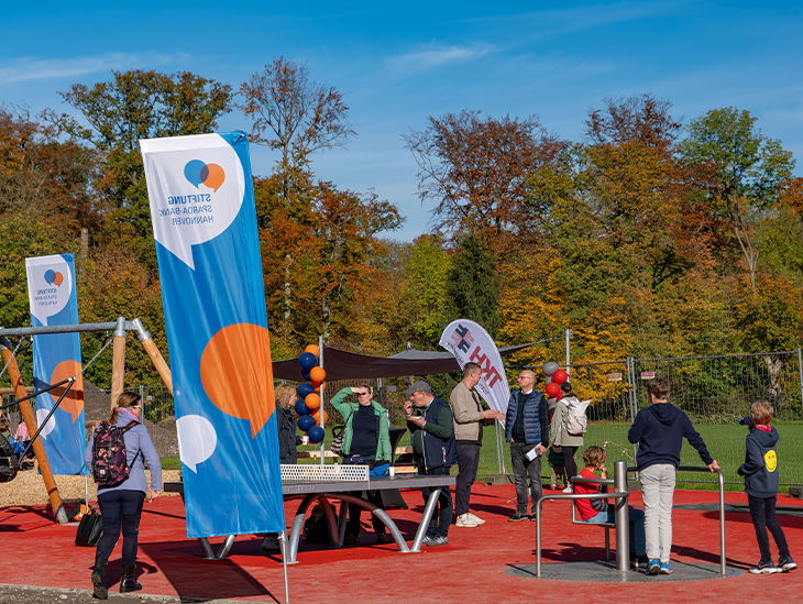 Erwachsene und Kinder spielen auf einem Spielplatz