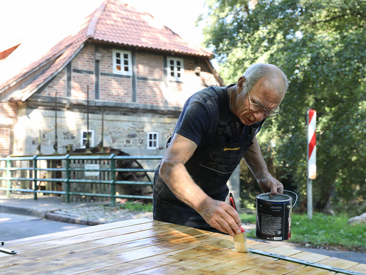 Mann lackiert Holz
