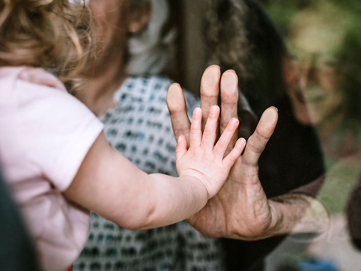 Erwachsene Frau und Kind berühren sich mit einer Hand