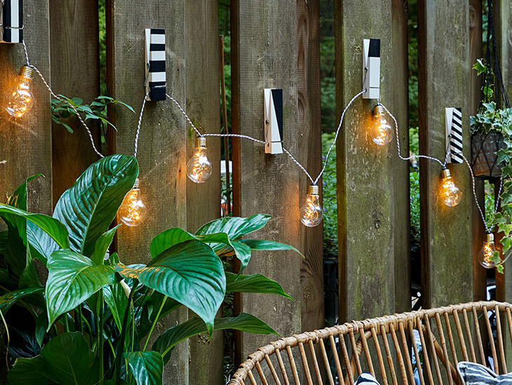 Lichterkette an einer Gartenwand