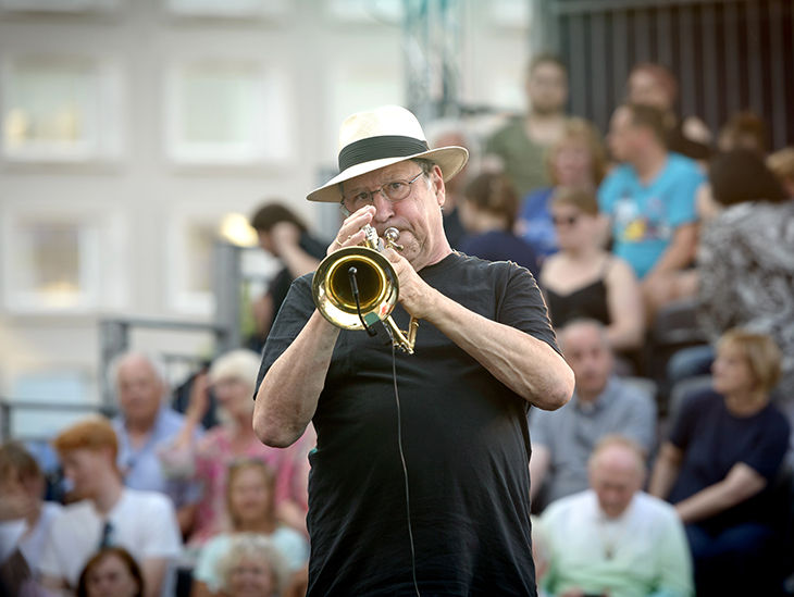 Mann der vor einem Publikum ein Instrument spielt
