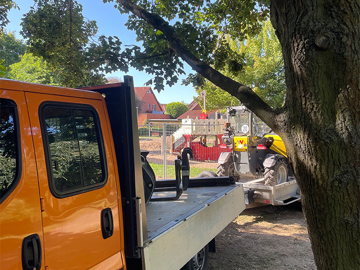 Ein Transporter mit und Anhänger auf dem ein Bagger steht