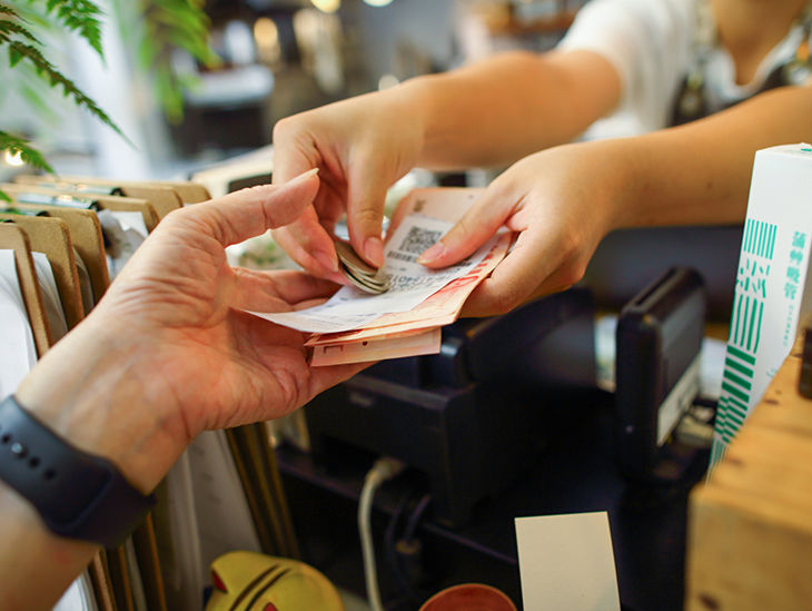 Es sind Hände sichtbar, die einander Bargeld reichen