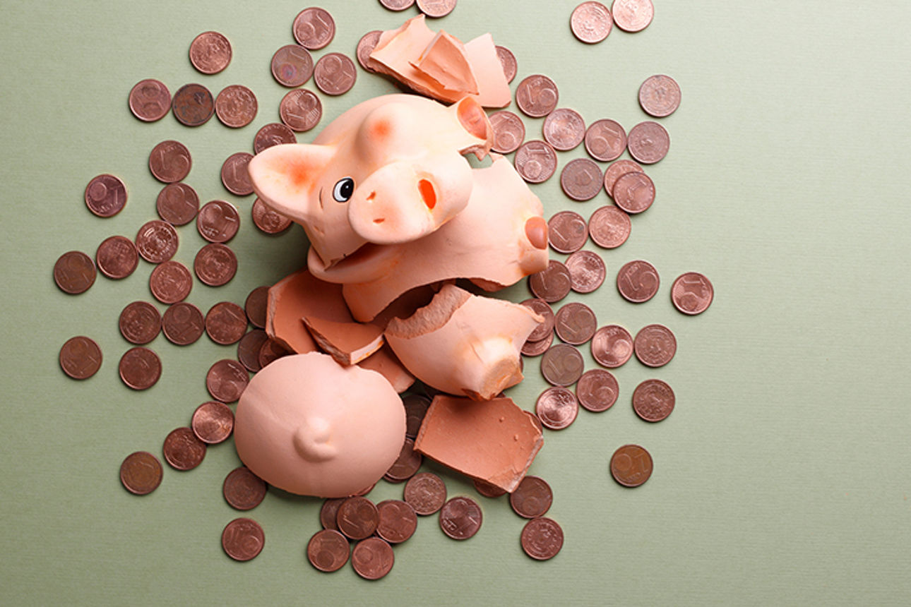Kaputtes Sparschwein mit viel Kleingeld