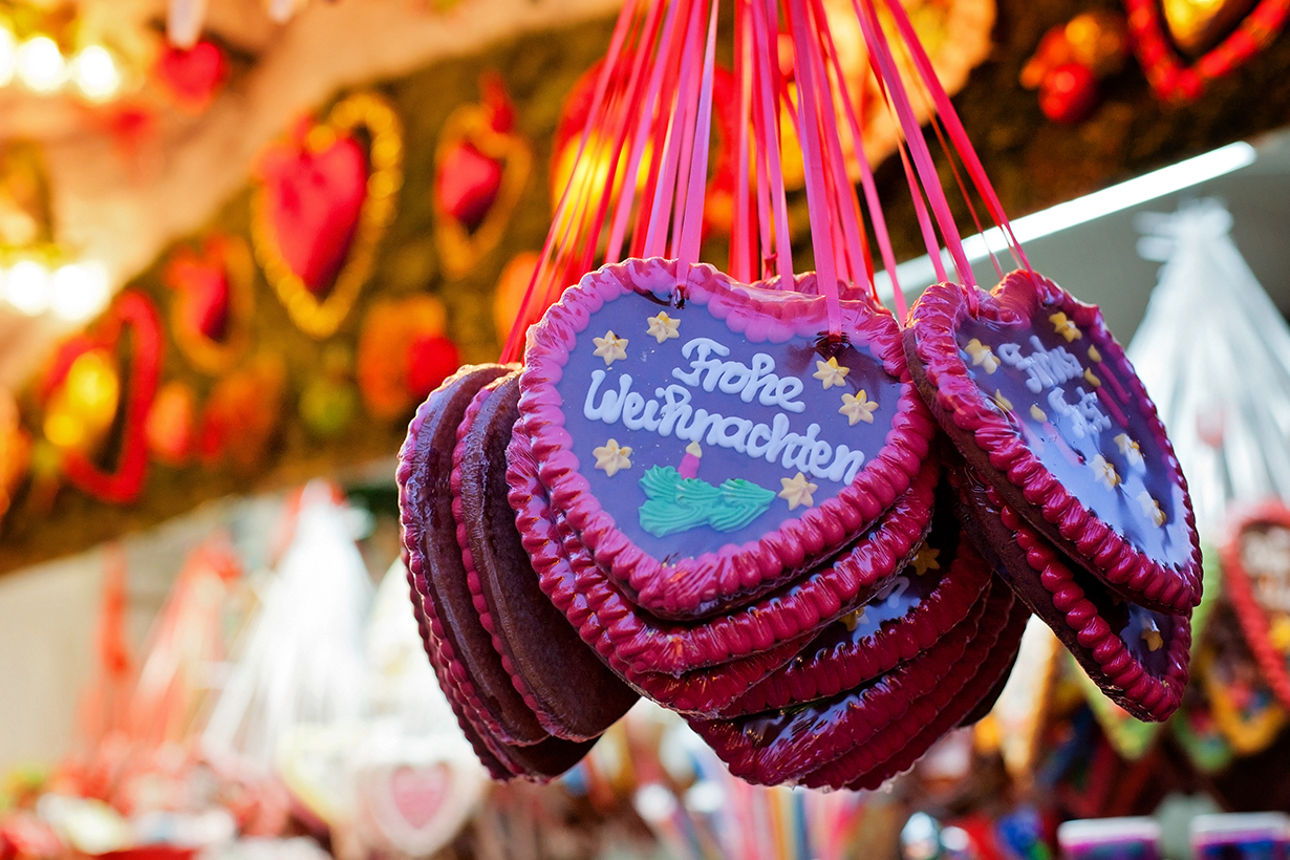 Lebkuchenherzen an Weihnachtsmarktstand mit Schriftzug Frohe Weihnachten