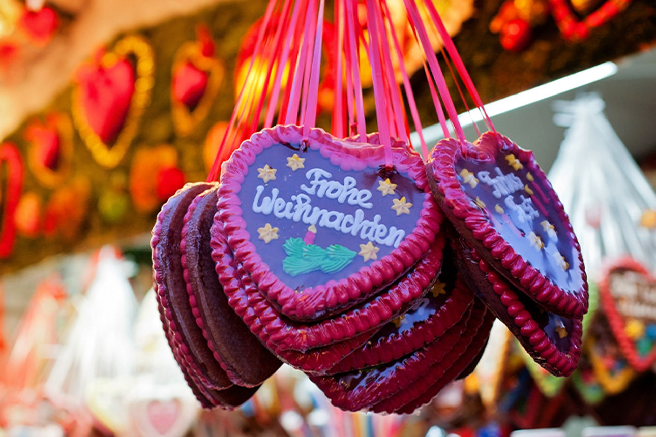 Lebkuchenherzen an Weihnachtsmarktstand mit Schriftzug Frohe Weihnachten