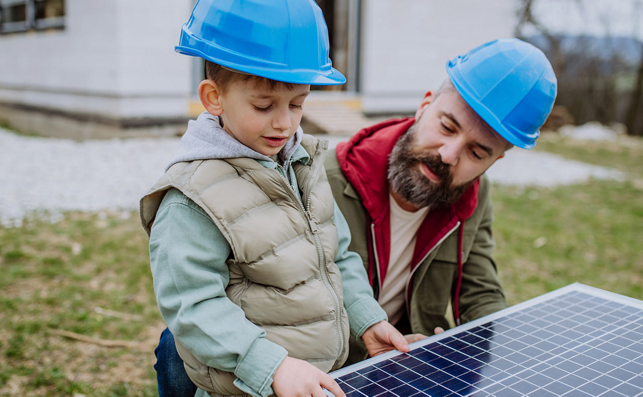 Mann zeigt Kind ein Solarpanel