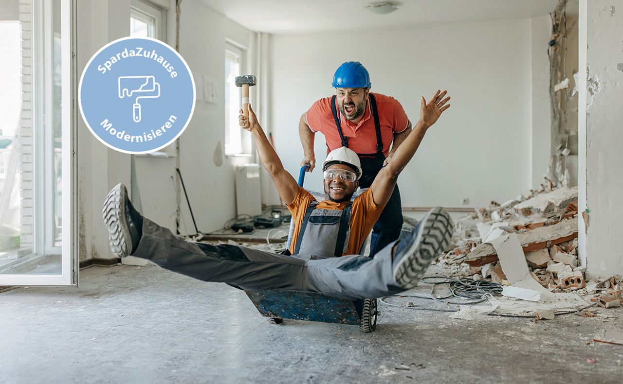 Zwei Handwerker haben Spaß in einem zu renovierenden Raum
