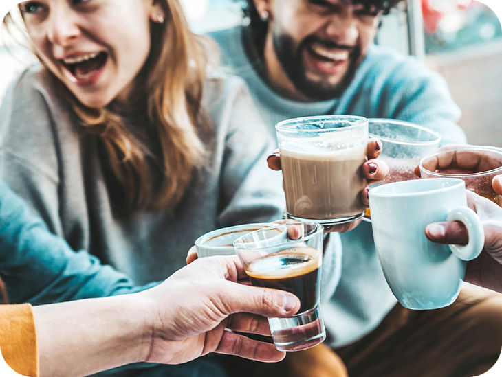 Freunde stoßen mit Kaffeetassen an