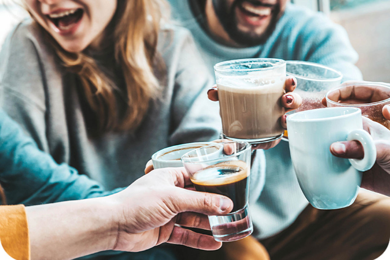 Freunde stoßen mit Kaffeetassen an