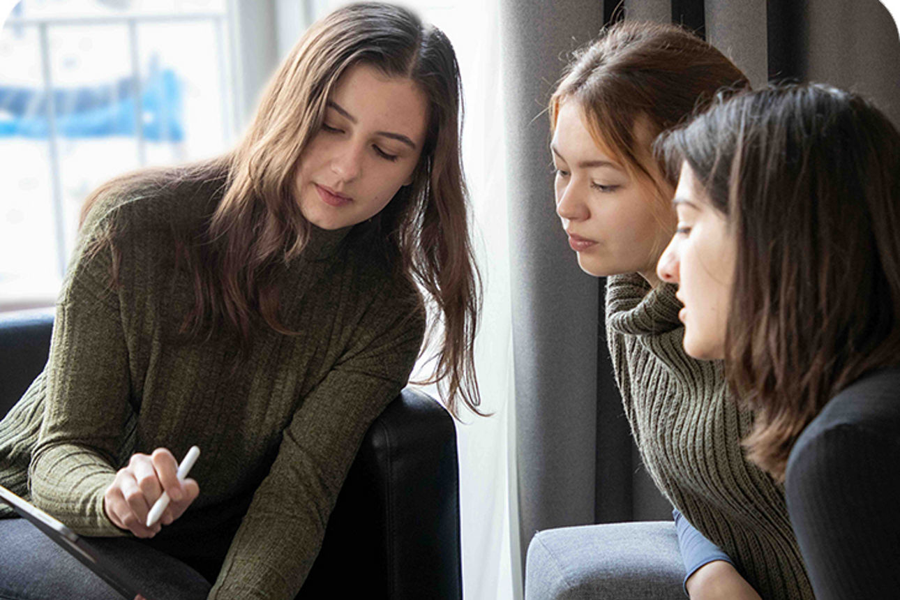 Drei Frauen schauen auf ein iPad