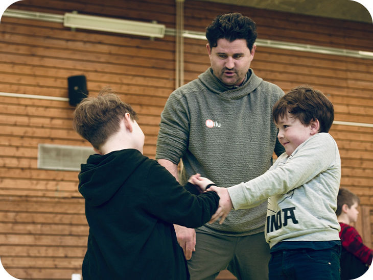 Zwei Jungs trainieren und ein Trainer beobachtet sie dabei