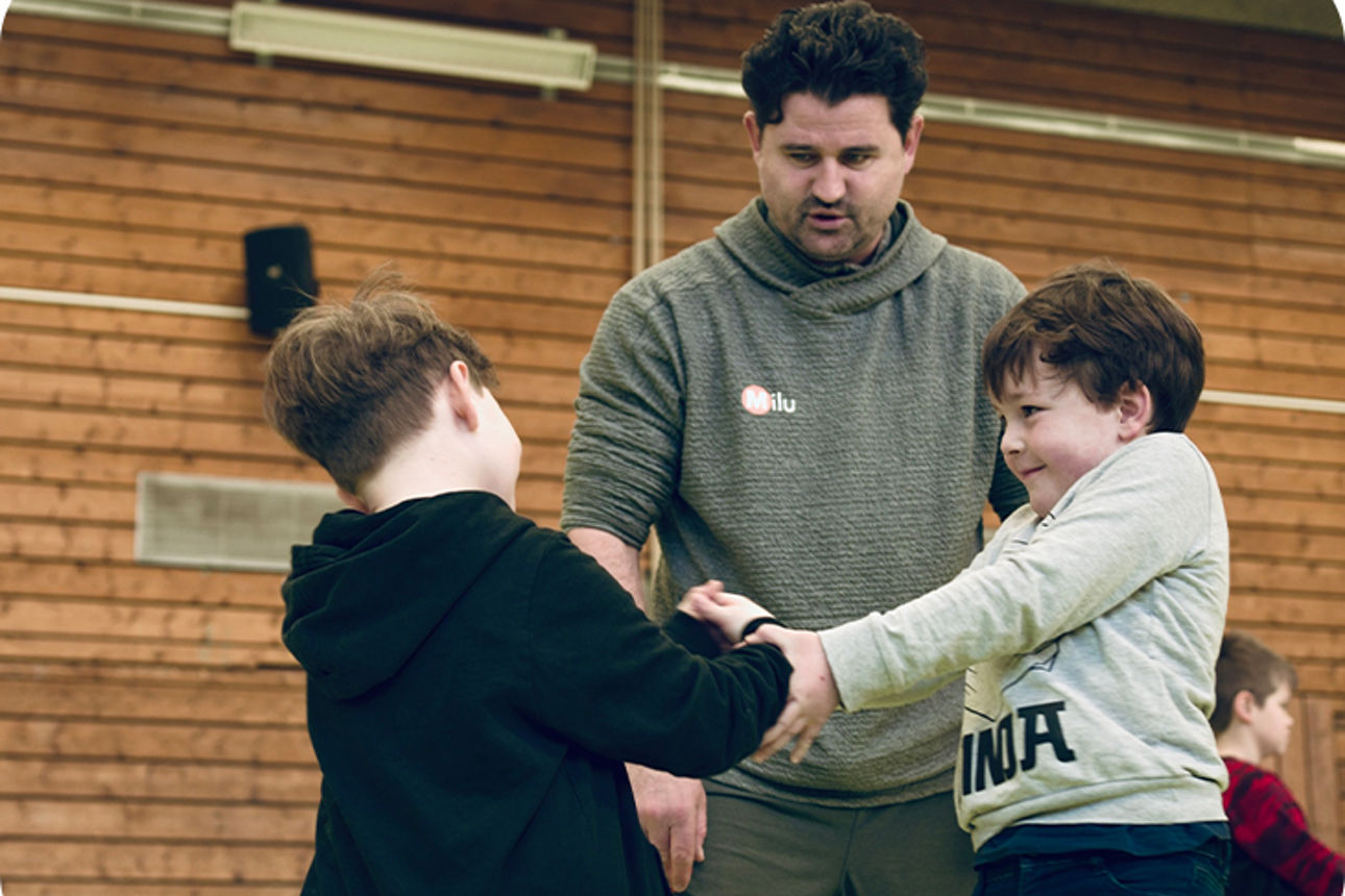 Zwei Jungs trainieren und ein Trainer beobachtet sie dabei