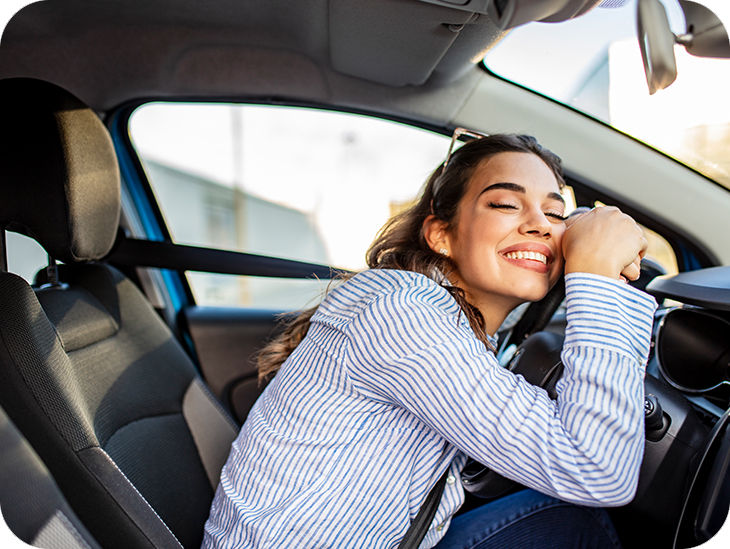 Frau sitzt lächelnd im Auto