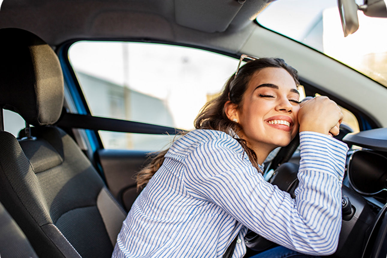 Frau sitzt lächelnd im Auto