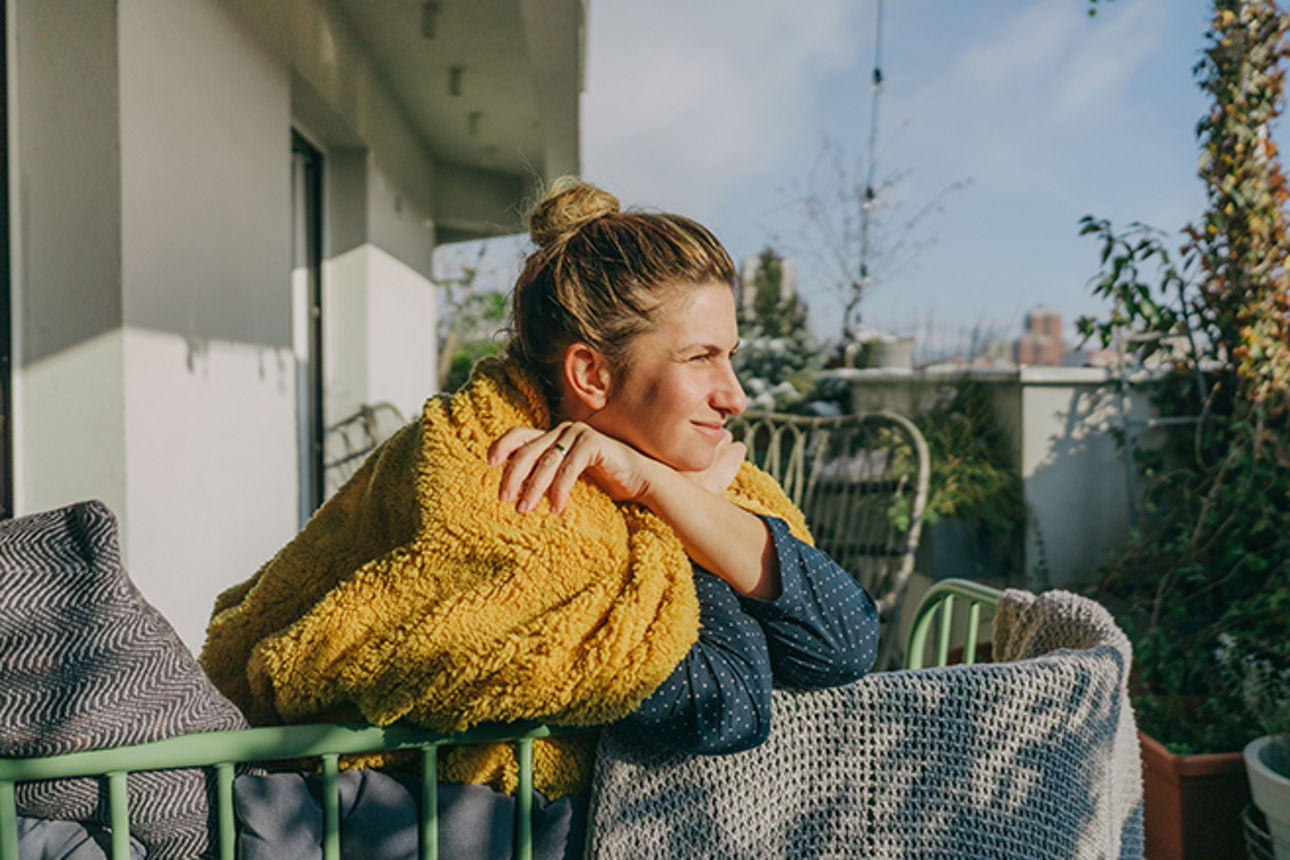 Frau sitzt auf einem Balkon