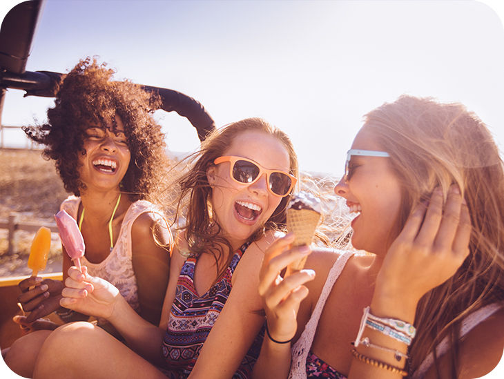 Drei Frauen sind am Strand und haben jeweils ein Eis in der Hand