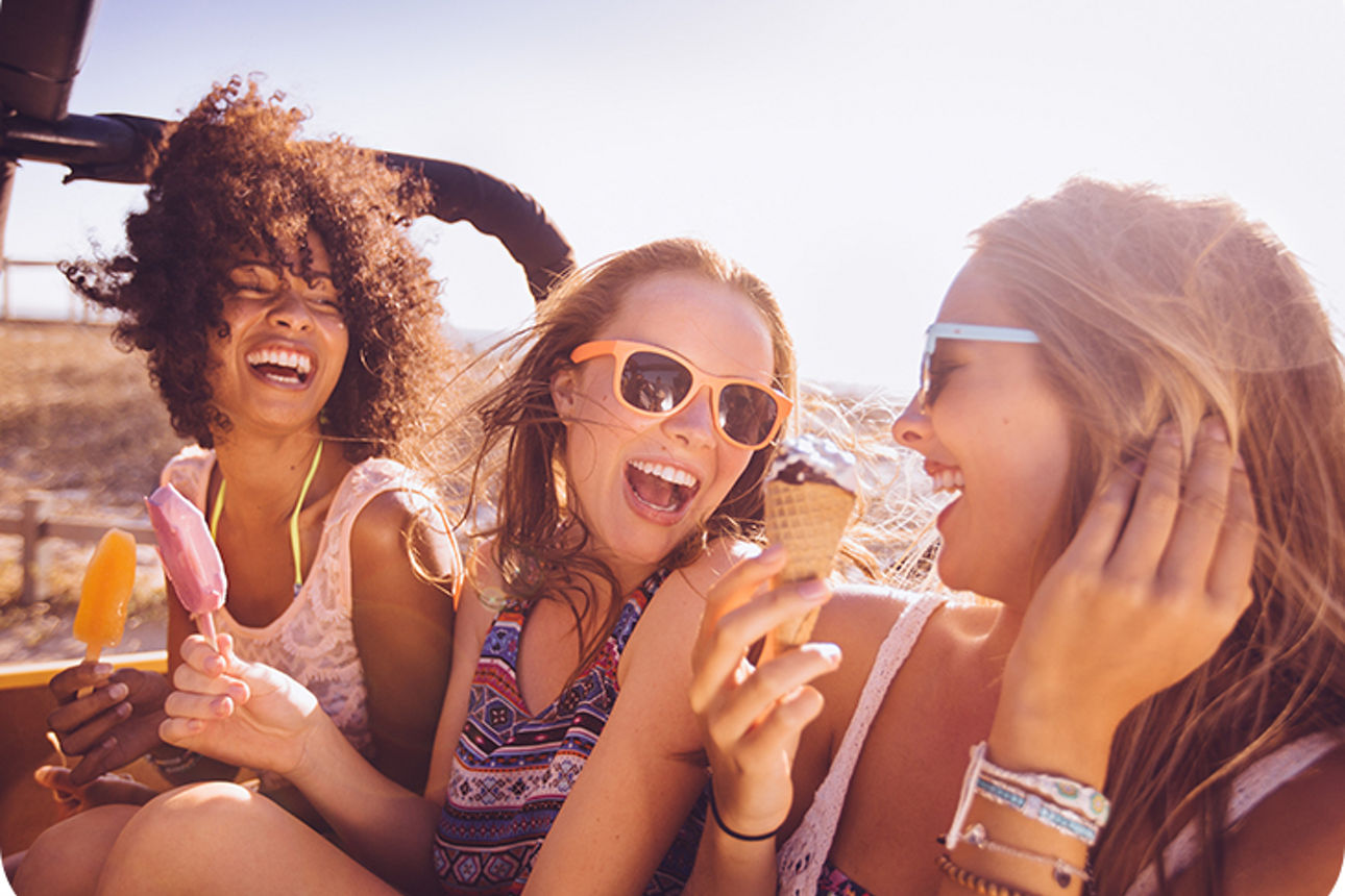 Drei Frauen sind am Strand und haben jeweils ein Eis in der Hand