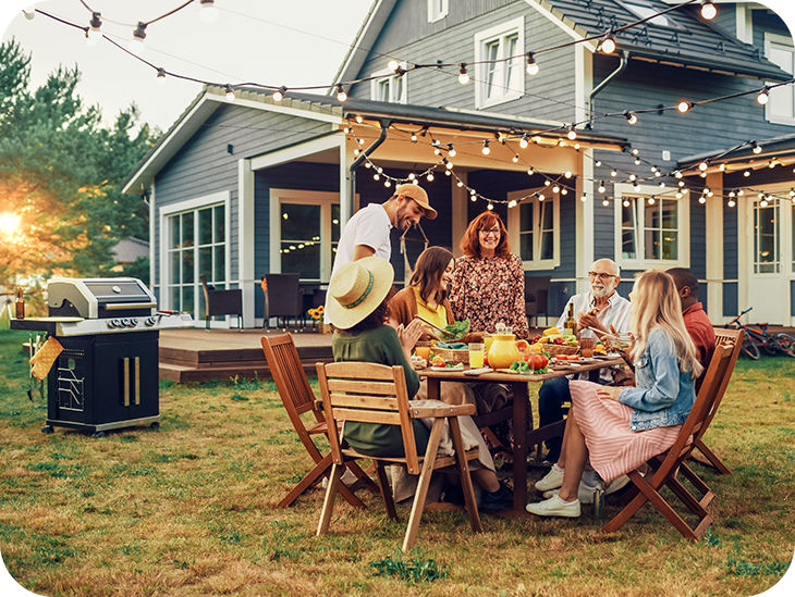 Familie sitzt im Garten an einem gedeckten Tisch