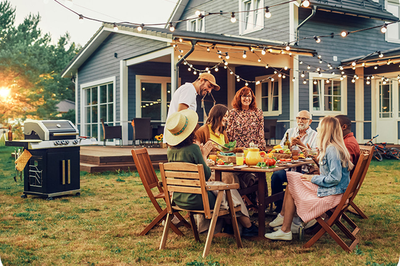 Familie sitzt im Garten an einem gedeckten Tisch