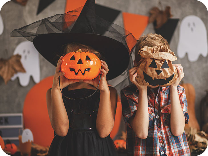 Zwei Kinder mit jeweils einer Halloween-Maske vor dem Gesicht