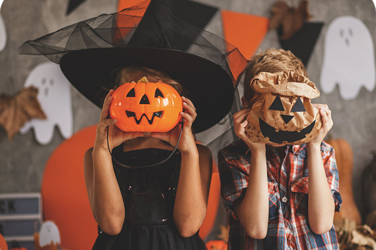 Zwei Kinder mit jeweils einer Halloween-Maske vor dem Gesicht
